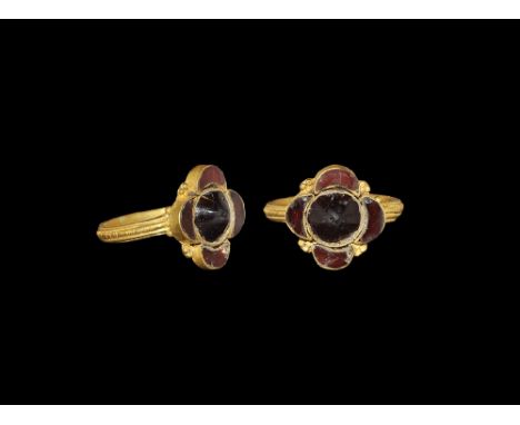  6th century AD. A flat-section gold hoop with applied beaded and plain wire fillets to the outer face; bezel of five cells w