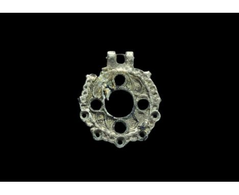  6th century AD. A bifacial silver pendant with parallel suspension lugs, discoid plaque with a large central circular hole a