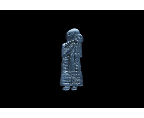  10th century AD. A flat-section silver plaque depicting a standing female in profile dressed in a long hatched robe, one han