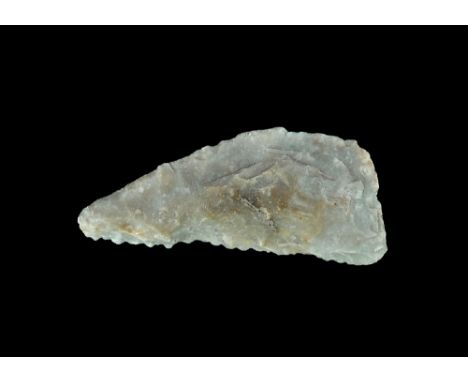  Neolithic, 3000-1500 BC. A triangular two-edged blade in grey flint with finely knapped serrations to one edge. 42 grams, 87