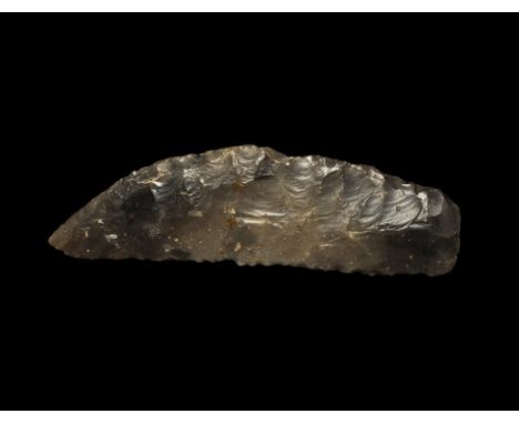  Neolithic, 5th-2nd millennium BC. A knapped bifacial asymmetric 'birds-bill' sickle knife in a transluscent grey-brown flint