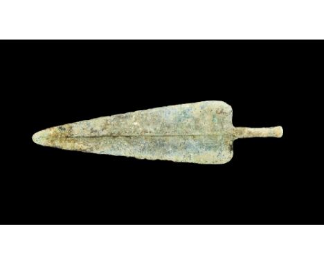  13th-6th century BC. A Bronze Age spearhead with leaf-shaped blade and rounded tip, pronounced medial rib and shoulder flang