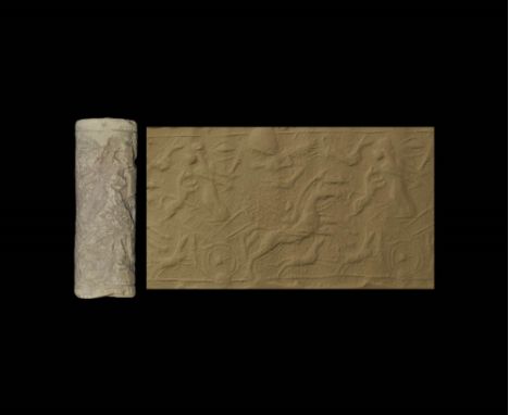  14th-11th century BC. A glazed composition cylinder seal with chariot and horses; accompanied by a typed and signed scholarl