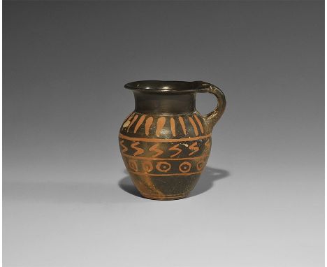  4th century BC. A ceramic Magna Graecia blackware juglet with rounded shoulder, short neck, everted rim, bifid strap handle 