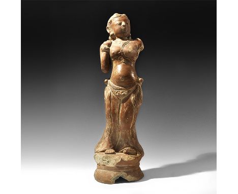  16th-18th century AD. A moulded ceramic figurine of an apsara temple dancer with curled hair to the brow, collar with beaded