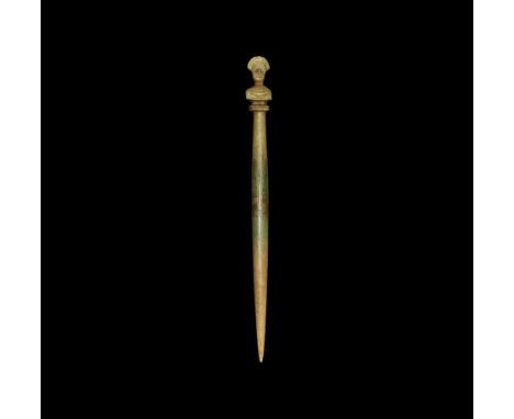  1st-3rd century AD. A round-section bone pin with hipped shank, the finial a female bust on pedestal base with tiara and chi