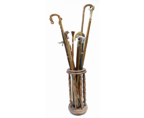 A collection of walking sticks including carved handles, animals, dogs, horn handles and circular wood stick stand (16)