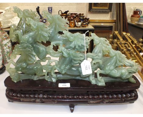 A mid-20th century Oriental 'jade' carving of five galloping horses, on wooden stand, in box, the carving 48cm long, 26cm hig