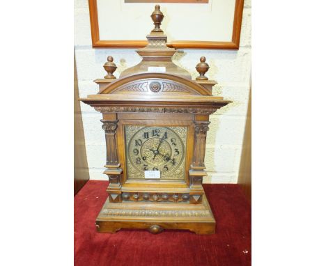 A walnut-cased mantel clock of architectural form with brass dial, the movement striking on a gong, 55cm high.