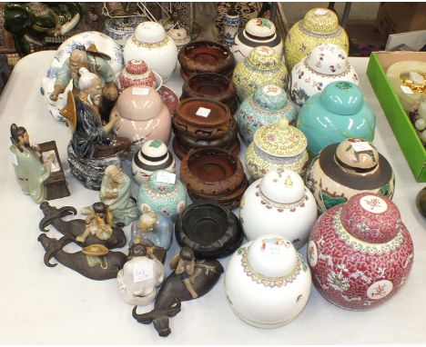 A collection of various modern coloured ceramic ginger jars and covers, with wooden stands, modern Oriental ceramic figures a