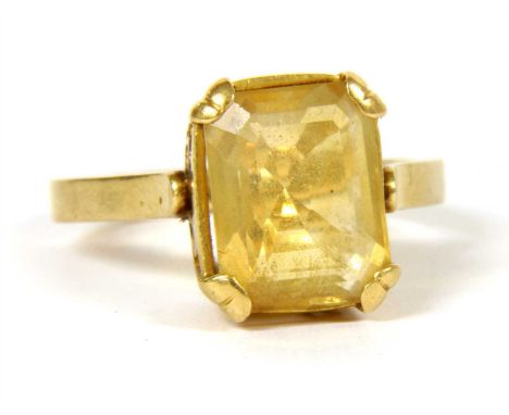 A single stone citrine ring, an octagonal step cut citrine, in four claw collet with pierced scrolling gallery and a plain po