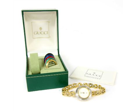 A gold plated quartz Gucci wristwatch, model 11/12, with circular dial with six interchangeable bezels, to integral torpedo a