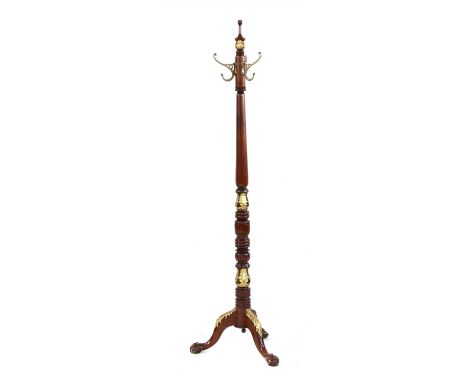 A Regency style mahogany hat stand, with three hooks on a turned and reeded stem with gilt anthemion and leaf decoration on a