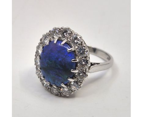An 18ct. white gold and platinum, diamond and black opal ring, set oval cabochon black opal to centre (approx. 13mm x 10mm x 