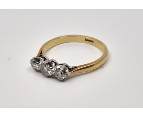 An 18ct. gold three stone diamond ring,&nbsp;set three graduated round brilliant cut diamonds (ETDW 0.45 carats), size UK P. 