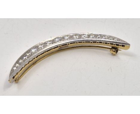 A white and yellow metal diamond crescent brooch,&nbsp;set seventeen round brilliant cut diamonds, the largest to centre with