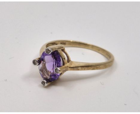 A 9ct. gold, amethyst and diamond ring, Birmingham 2003, four prong set mixed oval cut amethyst to centre, each prong flush s