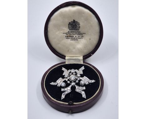 A white metal diamond stylised star form brooch,&nbsp;set round brilliant cut diamond to centre with an estimated weight of 0