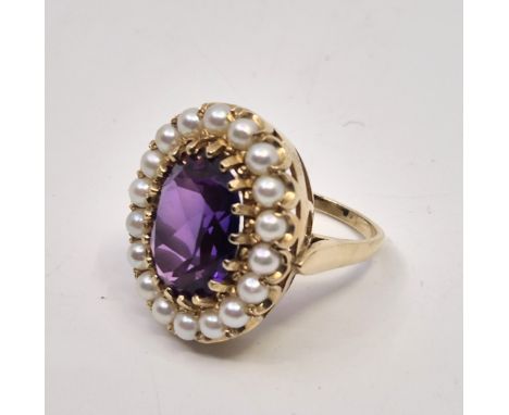 A 14ct. gold, violet synthetic sapphire and cultured pearl ring, set mixed oval cut violet synthetic sapphire to raised centr