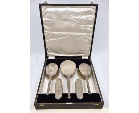 A five piece silver engine turned dressing table set, by Henry Clifford Davis, comprising hand mirror, a pair of hair brushes