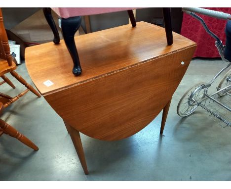 A vintage teak oval drop leaf dining table on tapered octagonal legs