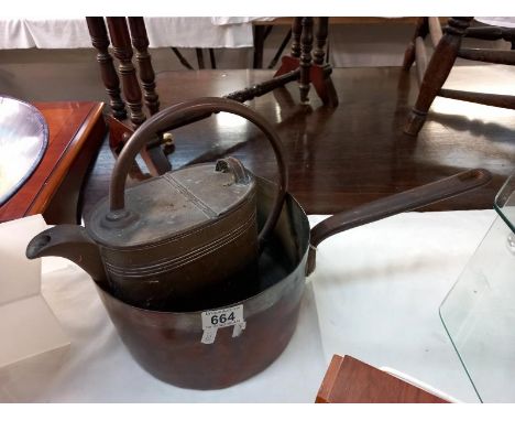 A Victorian copper saucepan with iron handle and vintage brass watering can.