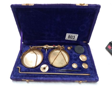 A cased set of brass postal gold weighing scales in purple velvet case