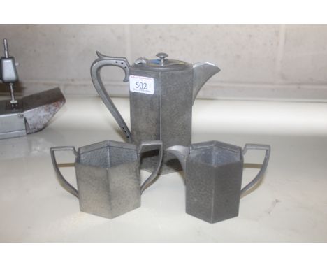 An English pewter hammered coffee set, comprising coffee pot, milk jug and sugar basin of hexagonal form