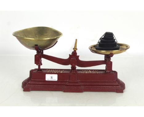 A set of ornate kitchen scales by Parnell & Sons Ltd. of Bristol with brass trays and a quantity of cast iron weights 