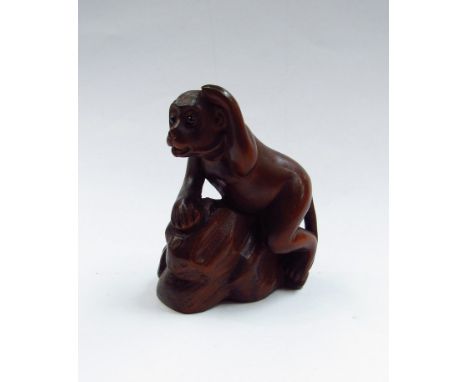 A netsuke of a monkey on a rock 