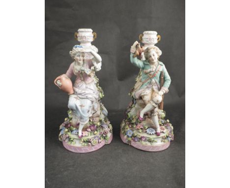 A pair of figural lamp bases adorned with flowers