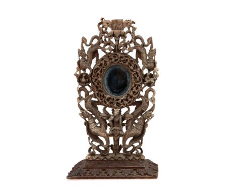 A Thai Tropical Hardwood Table Mirror, carved with mythical beasts and bodhisattva on a carved step base, 72.5 cm H