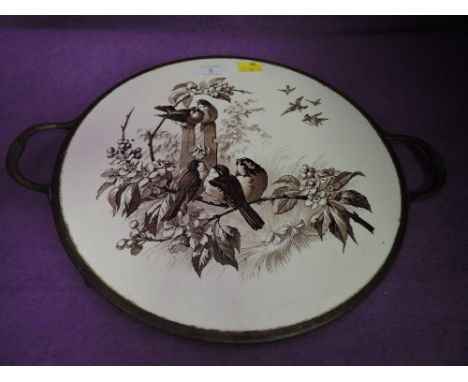 A ceramic tray with printed garden bird design and brass rim with twin handles