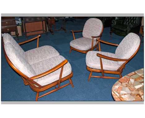 An Ercol Three Piece Cottage Suite with loose upholstered cushions. Comprising two seater sofa and two single wing arm chairs