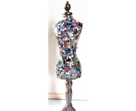 A MANNEQUIN/TAILORS DUMMY on tripod stand, covered in hunting and equestrian cut outs, 124cm high