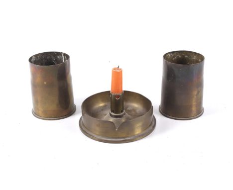 Three Trench Art shell cases in the form of two short vessels and a candlestick holder. The vases H10cm, the candlestick mark