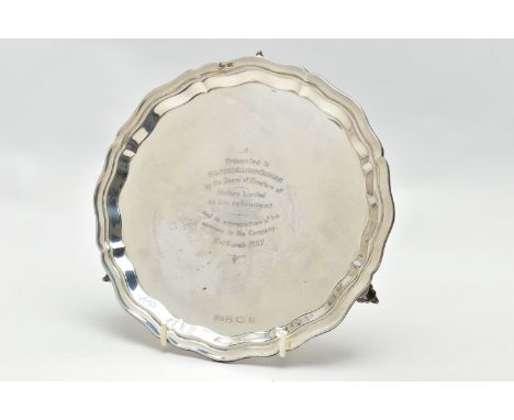 AN ELIZABETH II SILVER WAITER OF CIRCULAR FORM, pie crust border, the centre with presentation inscription, on three cast scr