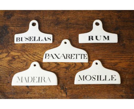 A group of five ceramic wine bin labels, 19th century, three inscribed with black lettering on a cream ground 'Madeira', 'Mos
