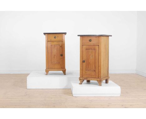 A pair of pitch pine bedside cabinets, late 19th century/early 20th century, each with a later fossil marble top above a door