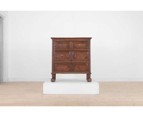 A James II oak chest of drawers, late 17th century, with three moulded drawers and bobbin decoration, raised on bun feet, 85c