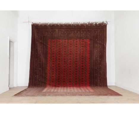 A Bokhara carpet, 20th century, Afghan, woven with repeating elephant foot motifs to a red ground, 413 x 312cmProvenance: The