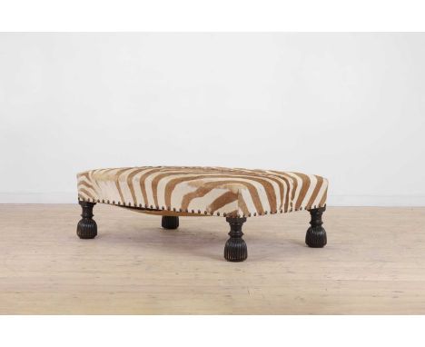 A stained wood and zebra skin stool, 20th century, the rectangular seat with studded detail, raised on lobed supports, 130cm 