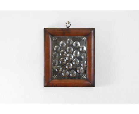A sorcerer's mirror, 19th century, the plate of rectangular form, with radiating circular concave inclusions, 30cm wide3cm de