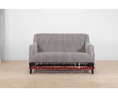 An ebonised wooden sofa by OKA, of recent manufacture, with coarse striped cotton fabric and tasselled detail, 138cm wide96cm
