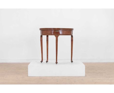 A George I walnut tea table, c.1740, of demilune outline, with a folding top and a papered well, raised on turned supports te