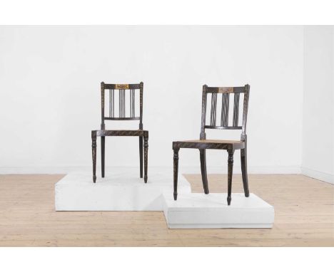 A pair of George III ebonised and painted wooden side chairs, c.1800, each with a pierced slat back, cane seat and turned sup