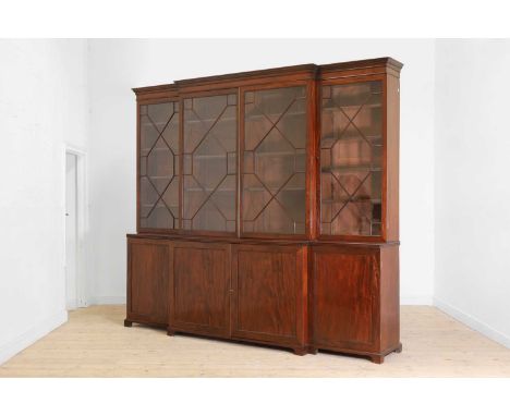 A George III mahogany library bookcase, c.1815, of breakfront outline, the upper section fitted with astragal-glazed doors an