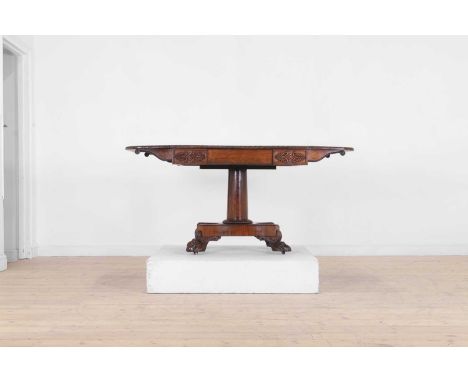 A George IV rosewood sofa table, c.1825-1830, the drop-flap rectangular top with a beaded edge, above a foliate-carved frieze