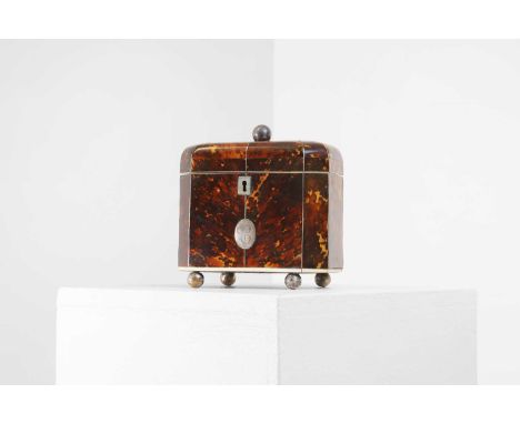 A George III tortoiseshell tea caddy,  19th century, of rounded and canted rectangular form, with metal stringing and a medal