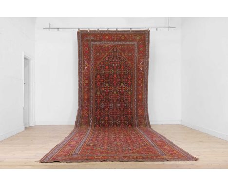 A Persian wool runner, 20th century, woven with a central diamond medallion and Herati motifs to a red ground, 587 x 197Condi